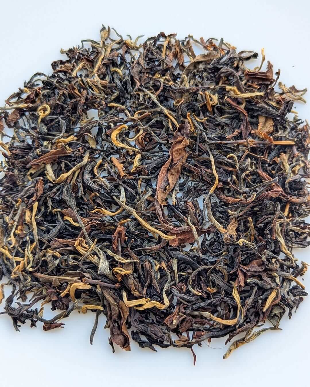 Loose leaf organic black tea from Arunachal Pradesh, showcasing golden-tipped clonal tea leaves.