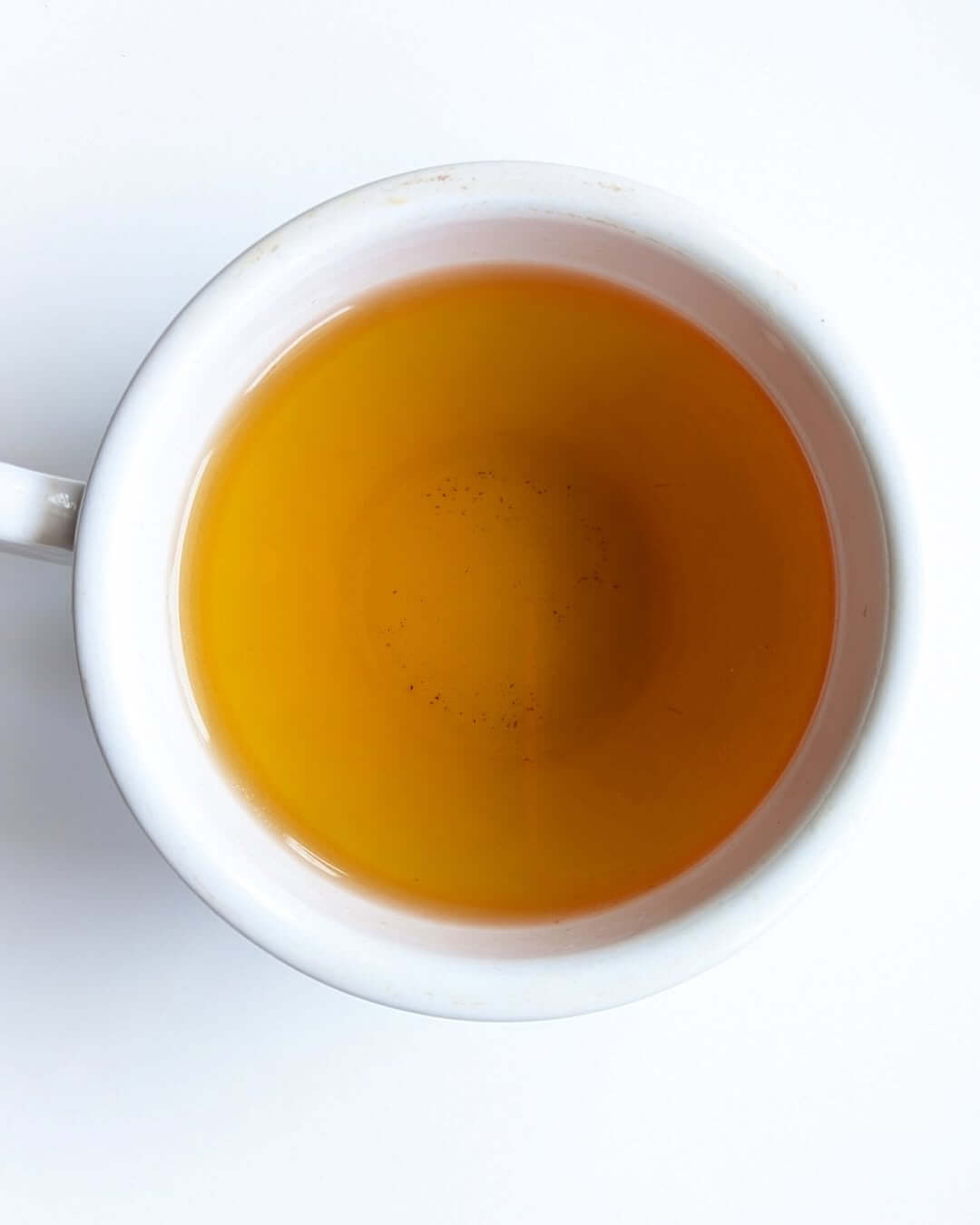 Warm cup of organic black tea, showcasing its rich amber color and inviting freshness.